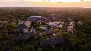An aerial view of a resort with multiple buildings, a swimming pool, and surrounding greenery. - Renaissance Bali Nusa Dua Resort (Nusa Dua)