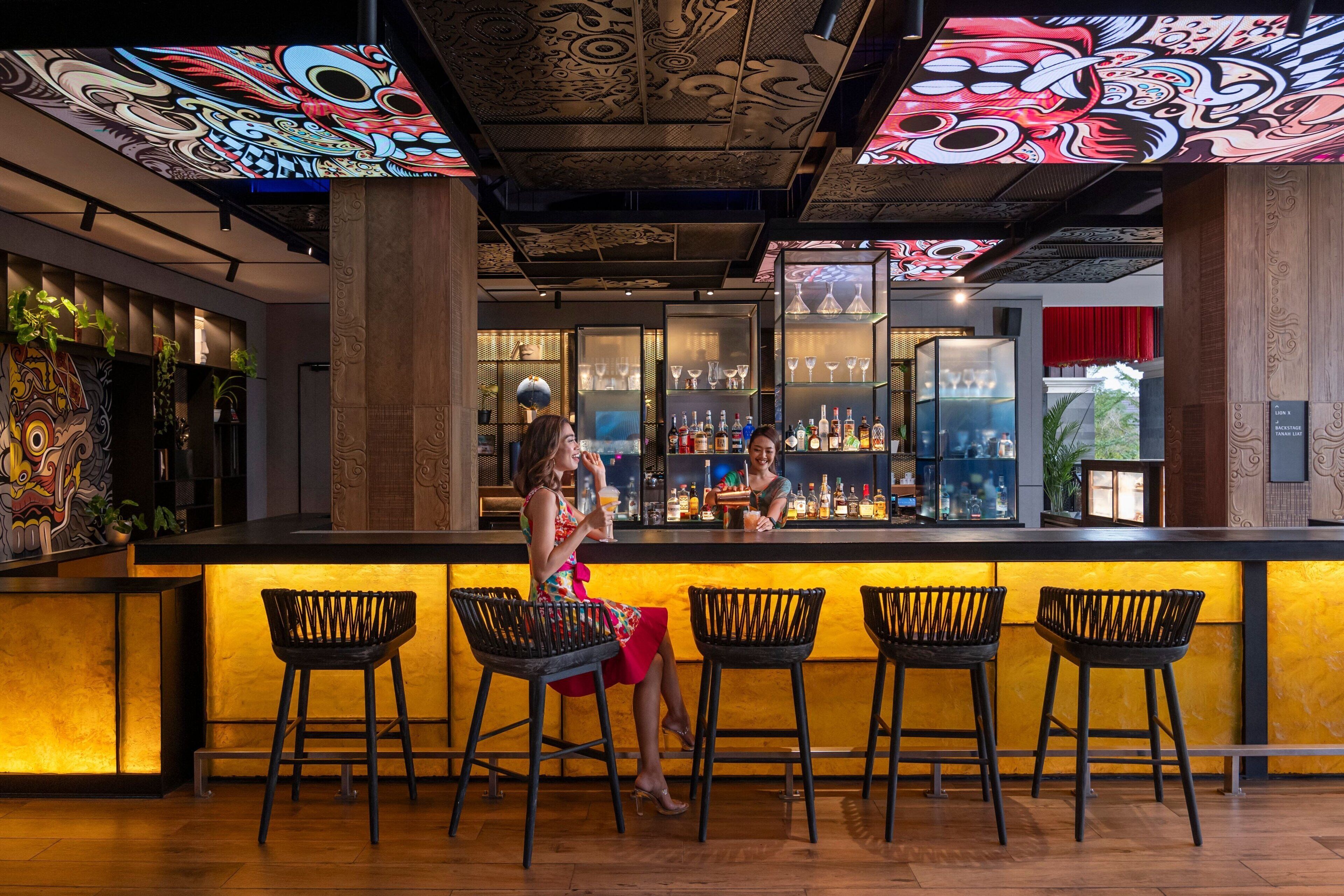 A bar area with a counter, bar stools, and a bartender.