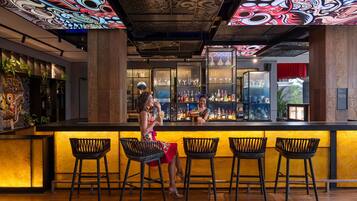A bar area with a counter, bar stools, and a bartender.