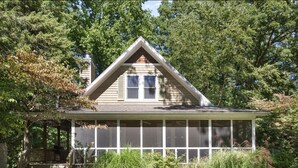 A house with a gabled roof, a covered porch, and a chimney. - Oak Dunes - Walk to the beach from this Cozy home (Union Pier)