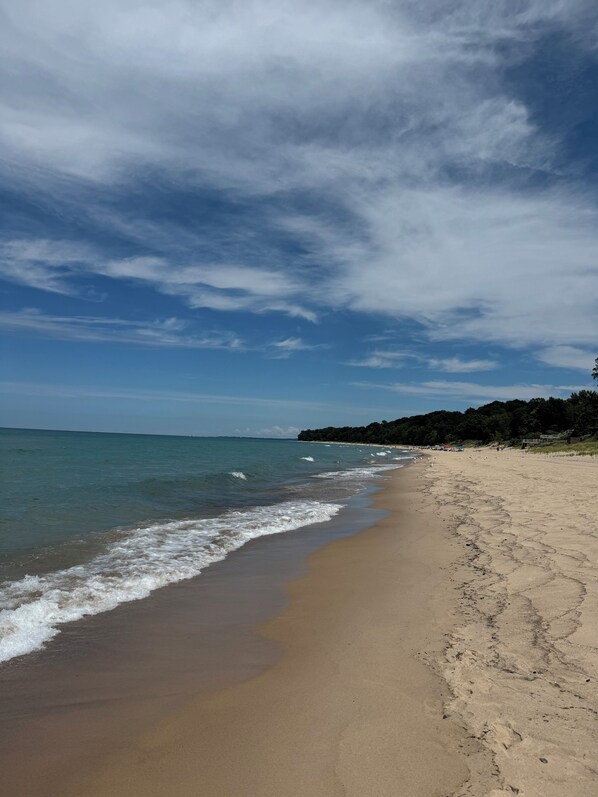 Una playa cerca, sillas reclinables de playa, toallas de playa