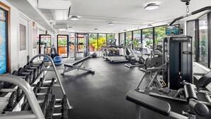 A gym with various exercise equipment, large windows, and a view of the outdoors. - *Luana Waikiki*No Resort Fees* (Honolulu)