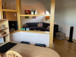 A compact living space with a sofa, a small table, a black lamp, and a decorative vase. - Am Nordwald ***** Vacation Apartment, Saterland - Am Nordwald ***** Vacation Apartment, (Saterland)