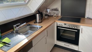 Une cuisine moderne dotée d’une verrière, d’appareils électroménagers en acier inoxydable et offrant une vue sur l’extérieur.