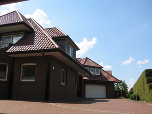 A residential house with a brick exterior, a garage, and a clear sky. - Am Nordwald ***** Vacation Apartment, Saterland - Am Nordwald ***** Vacation Apartment, (Saterland)