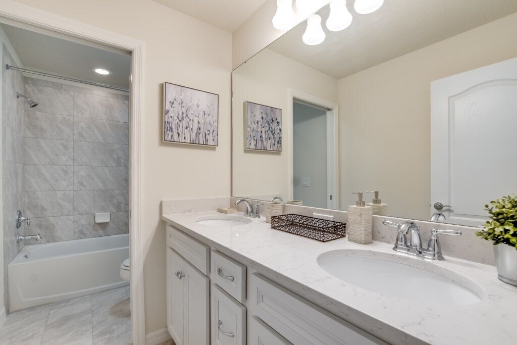 A modern bathroom with two sinks, a bathtub, and a shower.
