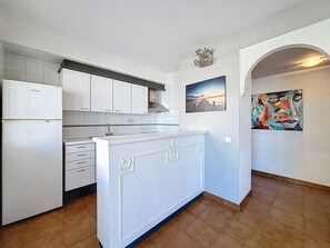 A kitchen with white cabinets, a built-in oven, and a tiled backsplash.
