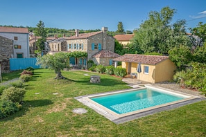 Een seizoensgebonden buitenzwembad, ligstoelen bij het zwembad