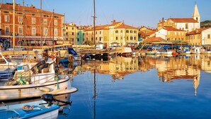 A marina with boats docked, buildings with red and yellow facades, and a church with a bell tower. - Rustic Villa Lavanda - Pool & Garden (Koper)