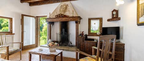 A rustic interior with a fireplace, wooden furniture, and a television.