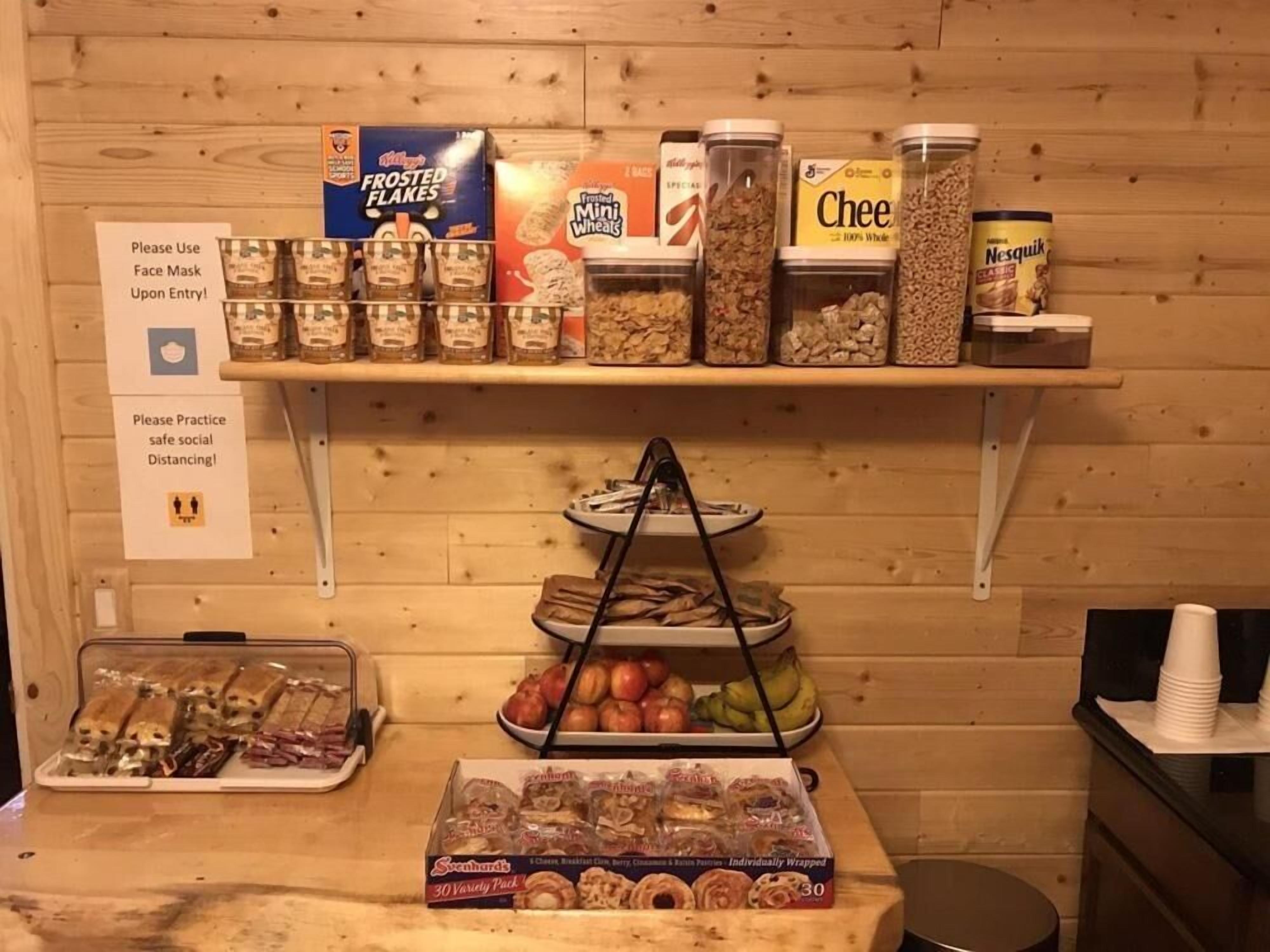 A breakfast buffet with cereal, cereals, and pastries.