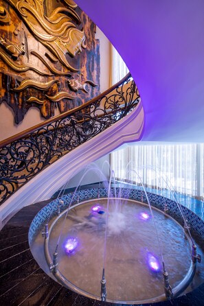 A luxurious indoor pool area with a curved staircase and ornate wall decorations. - Grand Palace Hotel & Resorts Sylhet (Sylhet)