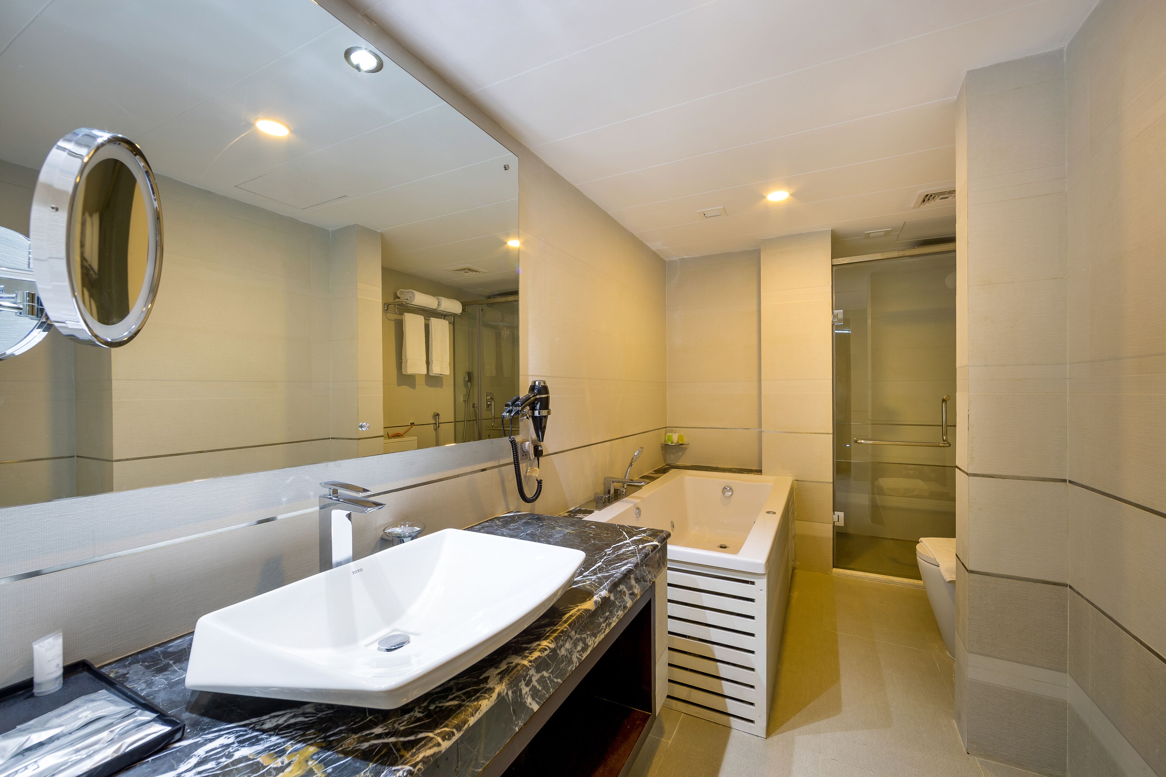 A modern bathroom with a large mirror, a sink, a bathtub, and a shower.