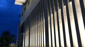 A modern building with vertical slats on the facade, illuminated windows, and a flat roof. - FFF Hotel (Hengchun)