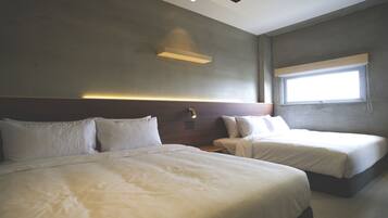 A hotel room with two beds, a large window, and a modern light fixture.