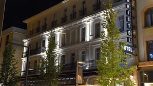 A multi-story hotel with a classic architectural style, featuring balconies and illuminated signage. - Work From Here at Bristol Hotel (Avignon)