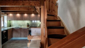 Een moderne keuken met houten kastjes, een inbouwfornuis en een aanrecht met een spoelbak.