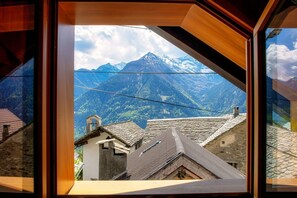 A mountain view through a window with traditional architecture.