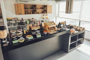 A buffet setup with various food items and a coffee station. - Spotty Hotels (Bogotá)