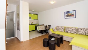 Ein Wohnzimmer mit einer Couch, einem Couchtisch und einem Essbereich mit Stühlen und einem Tisch.