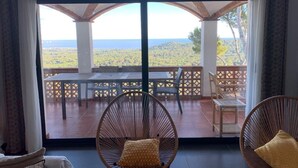 A room with a large window overlooking a terrace with a table and chairs. - Villa Pals very beautiful sea view and Medes islands, private swimming pool (Pals - Masos de Pals)