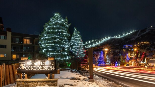 A snow-covered road with a sign for Snowflower Condominiums.