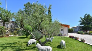 A grassy area with white sheep sculptures and a building with a red roof. - House 2065/32772 (Istria - Žminj), 20000m from the beach (Žminj)