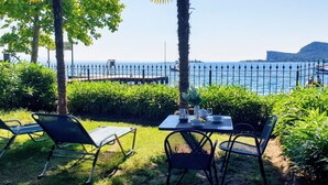 Un espace extérieur aménagé avec une table et des chaises, une vue sur la mer et une clôture.