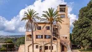 A building with a stone facade, multiple windows, and a staircase leading to an upper level. - Holiday Home “Sa Mina” with Garden, Pool, Terraces, Air Conditioning & WiFi (Selva)