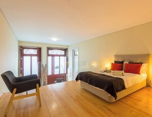 A bedroom with a bed, bedside table, and a chair.