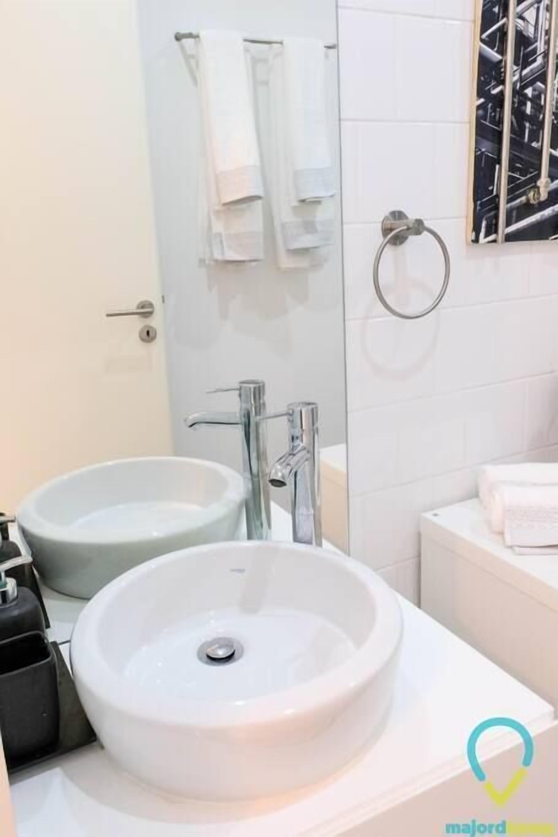 Une salle de bain avec deux lavabos, une douche et des toilettes.