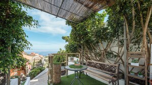 A patio with a bench, a small table, and a welcome sign. - Vacation Home 'Casa Reina Del Atlántico' with Sea View, Private Pool and Wi-Fi (Candelaria)