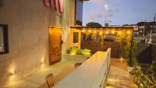 A modern building with a bar area, outdoor seating, and a sign that reads "LIV". - Liiv Costeira - Natal Ponta Negra (Natal)