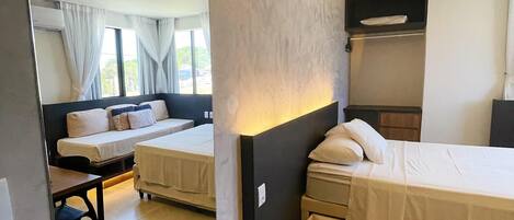 Habitación de hotel con dos camas, un escritorio y un espejo grande.