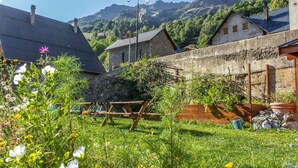 A rural setting with stone buildings, a wooden bench, and a stone wall. - Private terrace, warm & cosy lounge with fireplace (Vaujany)