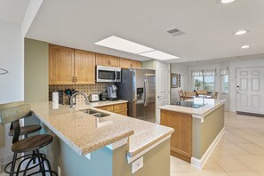 Enjoy cooking in this well-equipped kitchen with a central island, stainless steel appliances, and a granite countertop.