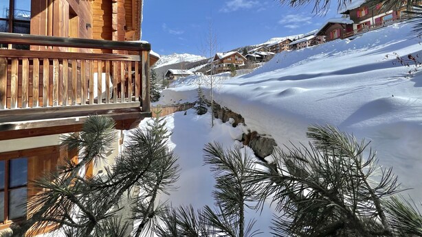 A wooden cabin with a balcony overlooking a snowy landscape and a clear blue sky. - Chalet Cirmolo (Livigno)