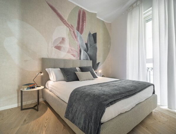 A modern bedroom with a large bed, a nightstand, and a wall mural. - Brera Design Apartment R&R (Milano)