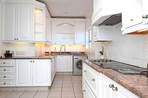 Full-sized fridge, stovetop, cookware/dishes/utensils