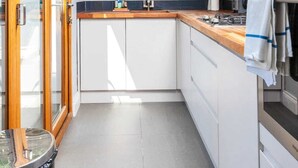 A modern kitchen with white cabinets, a wooden countertop, and a built-in oven.