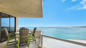 A balcony with a view of the sea, two green chairs, and a table. - ✨Gulf & Harbor Views~Beachfront Pool~Wlk2Beach~Fitness Center~3BR East Pass 308 (Destin)