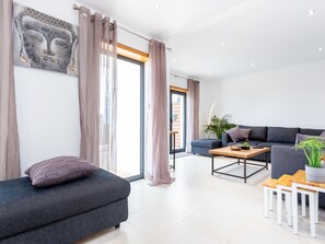 Una sala moderna con un sofá gris, una mesa de centro de madera y un sofá grisáceo.