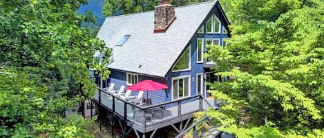 A two-story house with a deck and a staircase leading to a second level.