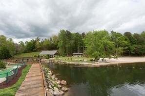 Ein Seeufer-Resort mit einer Holzterrasse, Picknicktischen und einem Pavillon.