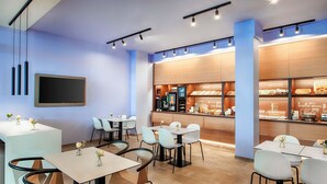 Un restaurant moderne doté d’un bar, de nombreuses tables et de chaises.