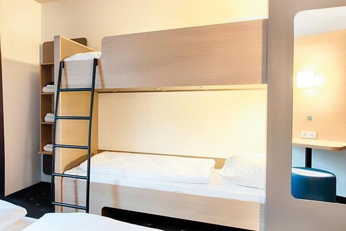 Habitación con literas, una mesita de noche y una lámpara.