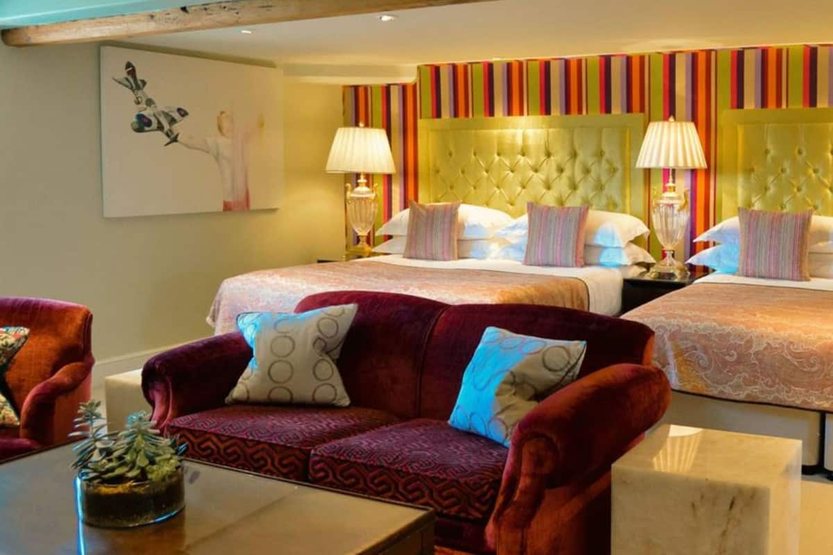 Una habitación de hotel con dos camas, un sofá y un cuadro en la pared.