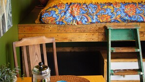 A cozy room with a bed, a table with a coffee pot, a mug, and a plate of pastries. - The Bolt Hole (Saint Merryn)