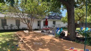 A backyard with a sandbox, a table with chairs, and a tree. - " BLUE SKYLARK"  is two blocks from main and one mile from Historic downtown.  (Fredericksburg)