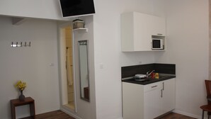 A compact kitchen with a microwave, a small sink, and a cabinet.